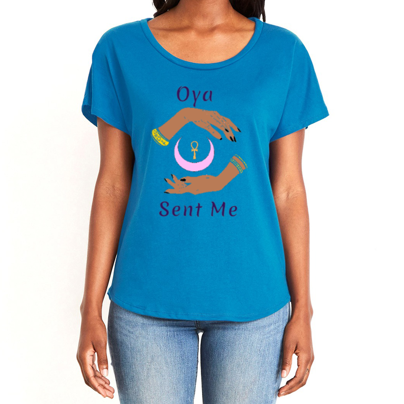 Feel the magic of wearing this comfortable royal blue women's T-Shirt with the name of the West African goddess Oya, and the message - "Oya Sent Me" in dark purple letters. It has brilliant graphics of hands circling a new moon with an ankh. Fabric laundered for relaxed fit.