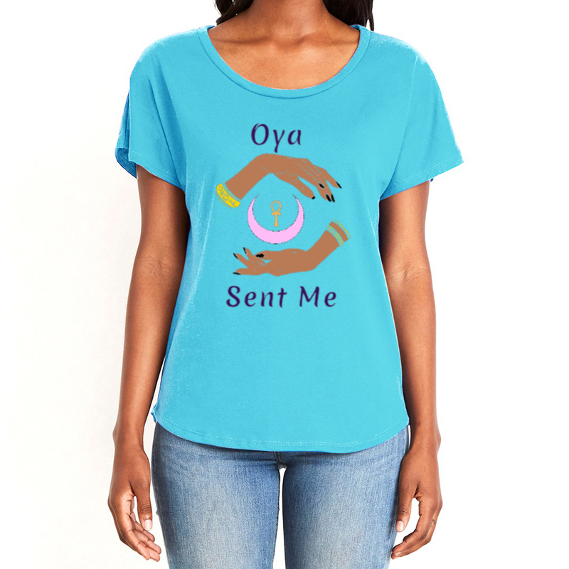 Feel the magic of wearing this comfortable light blue women's  T-Shirt with the name of the West African goddess Oya, and the message - "Oya Sent Me" in dark purple letters. It has brilliant graphics of hands circling a new moon with an ankh. Fabric laundered for relaxed fit.