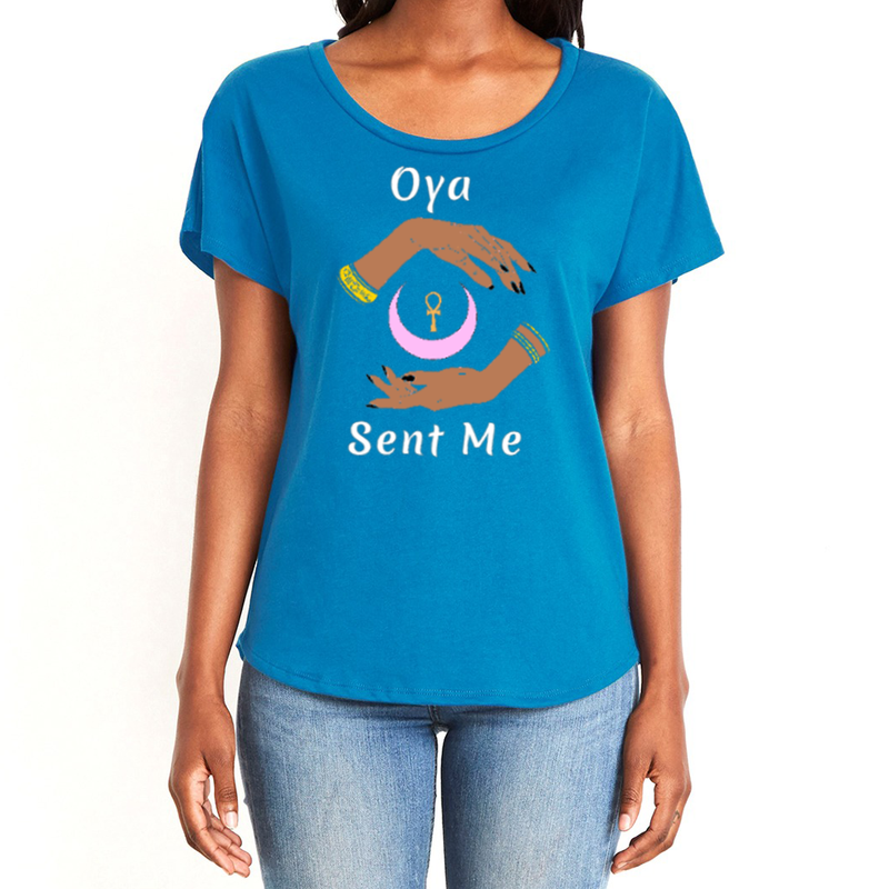 Feel the magic of wearing this royal blue comfortable women's T-shirt with the name of the West African goddess Oya, and the message - "Oya Sent Me" in white letters. It has brilliant graphics of hands circling a new moon with an ankh. It is fabric laundered for relaxed fit.