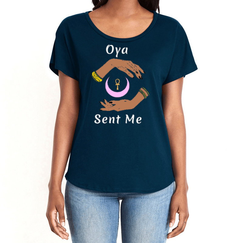 Feel the magic of wearing this navy blue comfortable women's T-shirt with the name of the West African goddess Oya, and the message - "Oya Sent Me" in white letters. It has brilliant graphics of hands circling a new moon with an ankh. It is fabric laundered for relaxed fit.